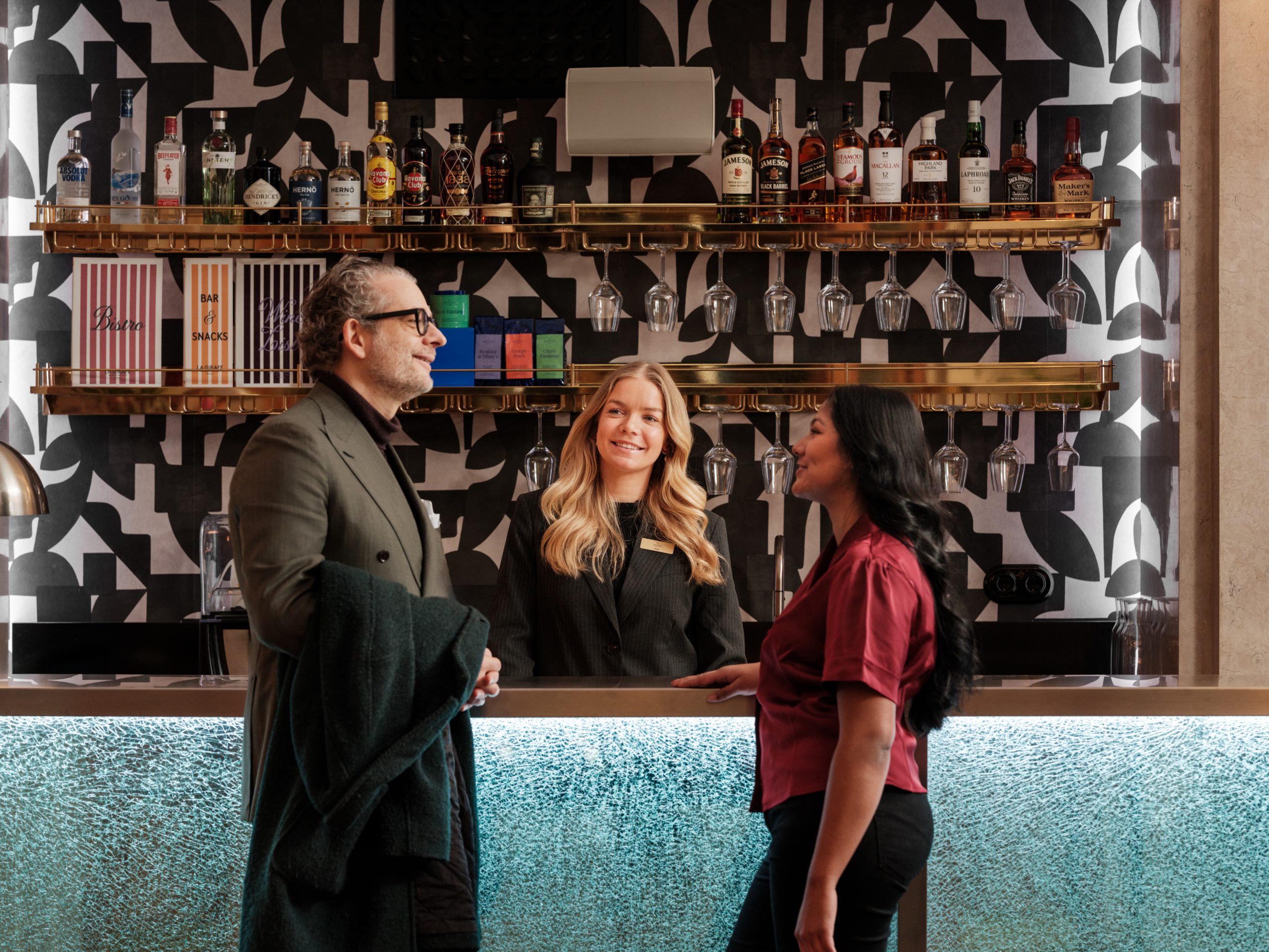 tre personer pratar vid receptionen