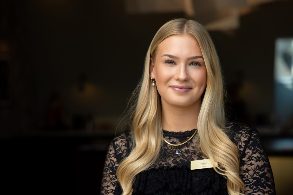 En prydlig medarbetare på Banken ler mot kameran.