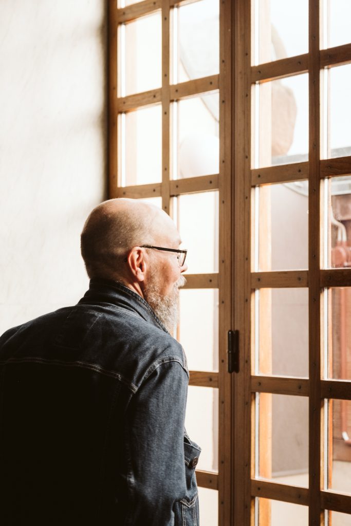 En person tittar ut ur ett fönster på jobbet